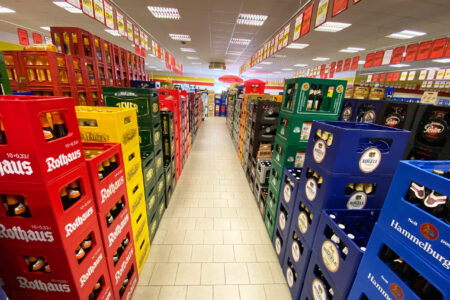 Regalgang mit gestapelten Bierkästen verschiedener Brauereien im Getränke Star Getränkemarkt in Trier