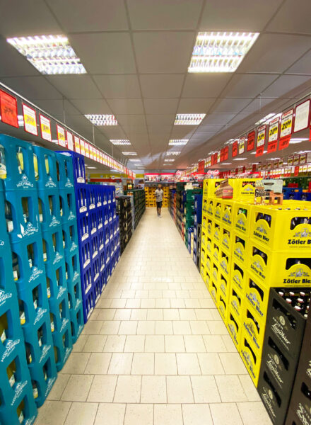 Langer Gang mit gestapelten Getränkekisten von Hochwald und Zötler Bier im Getränke Star Getränkemarkt in Trier