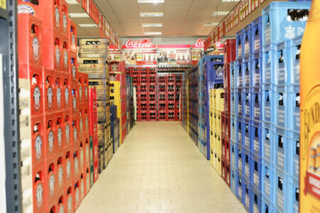 Langer Gang mit gestapelten Bierkisten und Coca-Cola Kisten im Getränke Star Getränkemarkt Trier