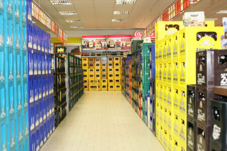 Langer Gang mit gestapelten Getränkekisten und Cola-Kisten im Getränke Star Getränkemarkt Trier