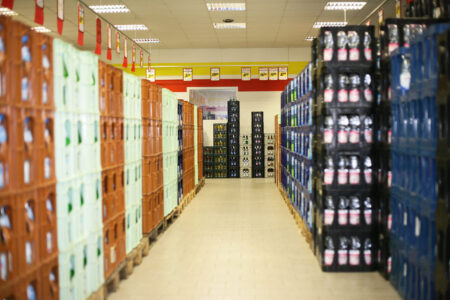 Langer Gang mit gestapelten Bier- und Wasserkisten im Getränke Star Getränkemarkt Trier