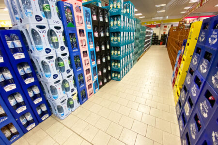 Gang mit gestapelten Mineralwasserkisten verschiedener Marken im Getränke Star Getränkemarkt in Trier