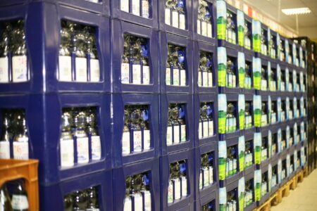 Mehrere Reihen gestapelter Mineralwasserkisten mit Glasflaschen im Getränke Star Getränkemarkt in Trier