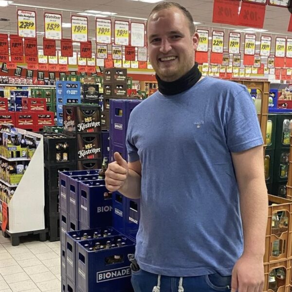 Mitarbeiter im Getränke Star Getränkemarkt in Trier zwischen Getränkekisten und Aktionsschildern