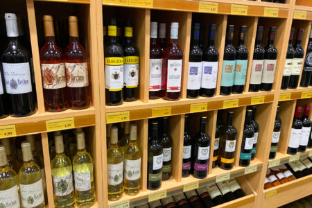 Holzregal mit verschiedenen Rotwein-, Weißwein- und Roséweinflaschen im Getränke Star Getränkemarkt in Trier