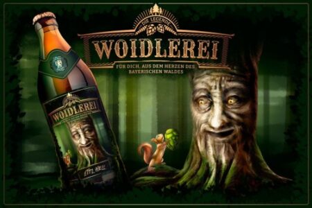 Woidlerei Bierflasche mit Waldmotiv und Baumfigur aus dem Bayerischen Wald auf einem Werbebild